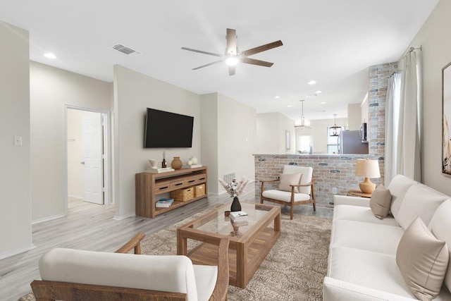 living area with light wood-style flooring, a ceiling fan, visible vents, and recessed lighting