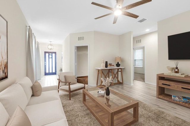 living area with light wood-style flooring, ceiling fan, and visible vents