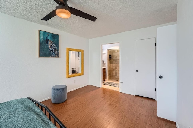 14487 Robert I Walker Blvd, Austin, TX 78728 - unfurnished bedroom featuring a textured ceiling, wood finished floors, a ceiling fan, and connected bathroom