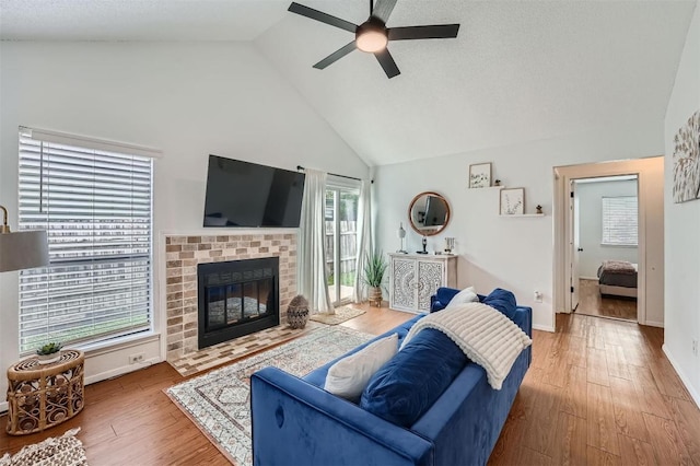 14487 Robert I Walker Blvd, Austin, TX 78728 - living area with ceiling fan, high vaulted ceiling, a tiled fireplace, and wood finished floors