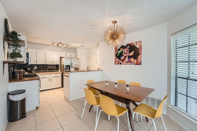 14487 Robert I Walker Blvd, Austin, TX 78728 - dining room featuring a chandelier, a textured ceiling, light tile patterned flooring, and healthy amount of natural light