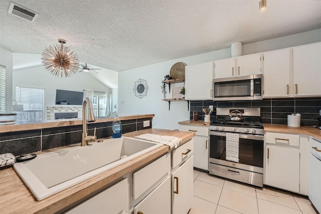 14487 Robert I Walker Blvd, Austin, TX 78728 - kitchen featuring appliances with stainless steel finishes, decorative backsplash, plenty of natural light, and a textured ceiling