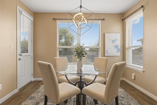 dining room with wood finished floors, a chandelier, and baseboards