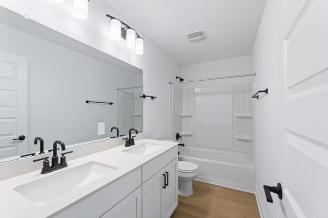 13320 Lapoynor St, Manor, TX 78653 - bathroom featuring double vanity, shower / tub combination, and wood finished floors