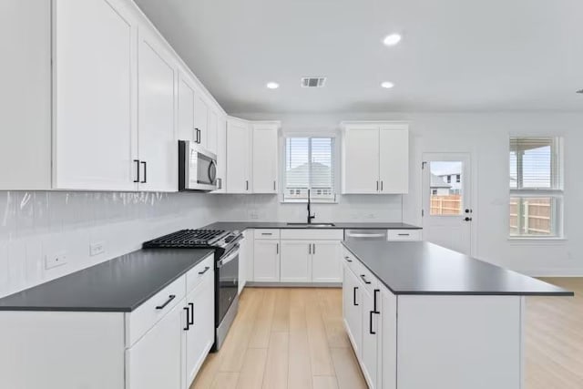 13320 Lapoynor St, Manor, TX 78653 - kitchen featuring appliances with stainless steel finishes, dark countertops, healthy amount of natural light, and recessed lighting