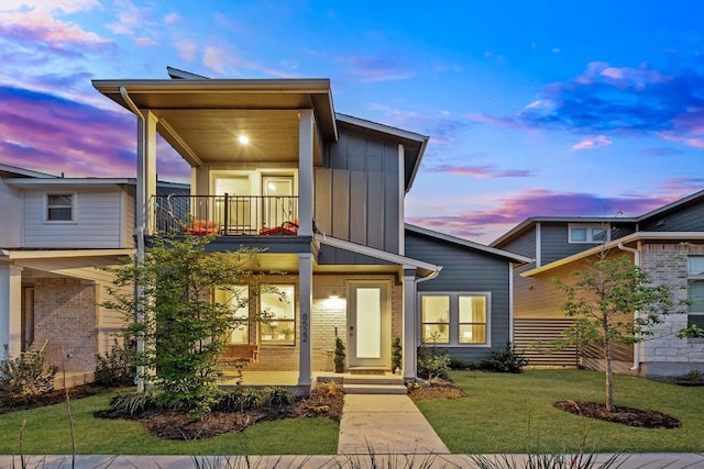 8522 Leroi Dr, Austin, TX 78744 - view of front of home with a balcony, board and batten siding, brick siding, and a front yard