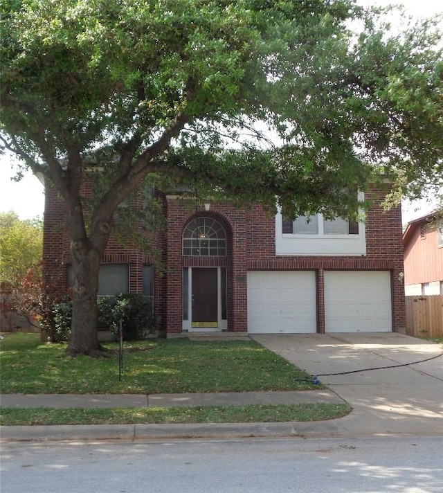 view of front of house with a front yard, brick siding, driveway, and an attached garage