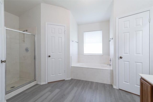 15406 Ecorio Dr, Austin, TX 78728 - bathroom with wood finished floors, a bath, a shower stall, and vanity