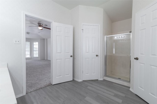 15406 Ecorio Dr, Austin, TX 78728 - bathroom with wood finished floors, a shower stall, a ceiling fan, baseboards, and vaulted ceiling