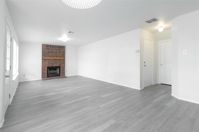 15406 Ecorio Dr, Austin, TX 78728 - unfurnished living room featuring light wood-style flooring and a brick fireplace