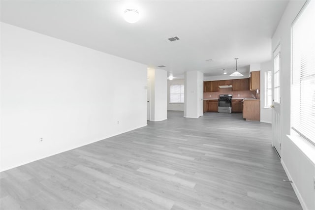 15406 Ecorio Dr, Austin, TX 78728 - unfurnished living room with a sink, light wood-style flooring, and baseboards
