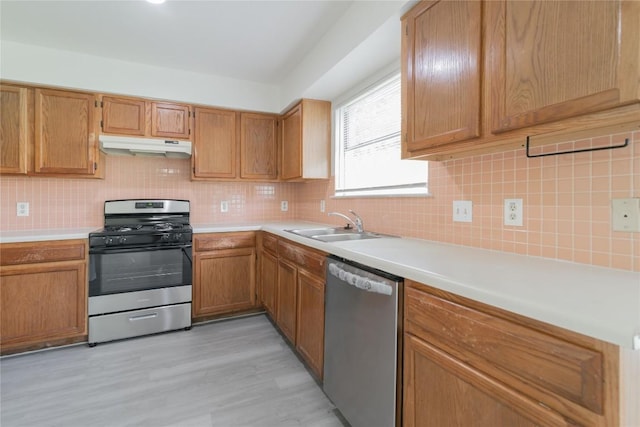15406 Ecorio Dr, Austin, TX 78728 - kitchen with stainless steel appliances, under cabinet range hood, decorative backsplash, light countertops, and light wood-type flooring