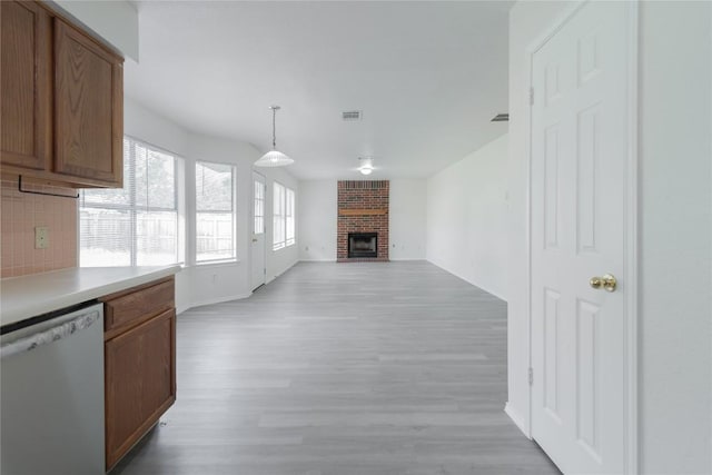 15406 Ecorio Dr, Austin, TX 78728 - kitchen with dishwasher, light wood-style floors, decorative backsplash, and light countertops