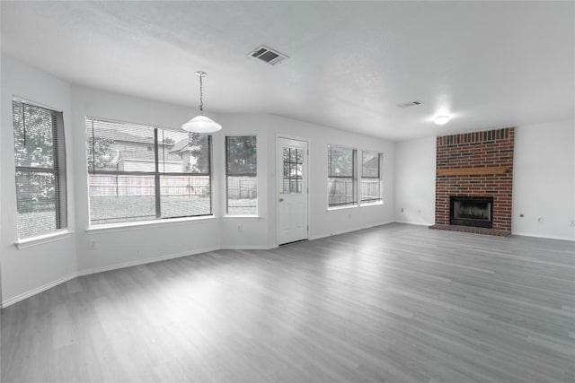 15406 Ecorio Dr, Austin, TX 78728 - unfurnished living room featuring wood finished floors, plenty of natural light, and a brick fireplace