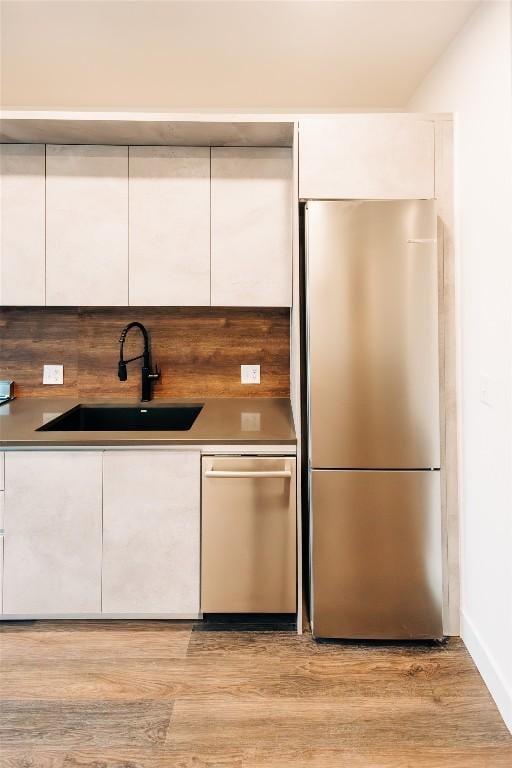 4315 S Congress Ave Unit 520, Austin, TX 78745 - kitchen featuring a sink, white cabinetry, light wood-style floors, and stainless steel appliances