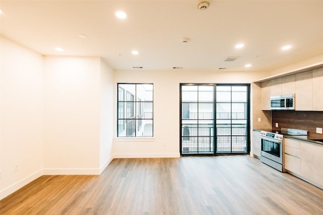 4315 S Congress Ave Unit 520, Austin, TX 78745 - kitchen with stainless steel appliances, light wood-style flooring, baseboards, and visible vents