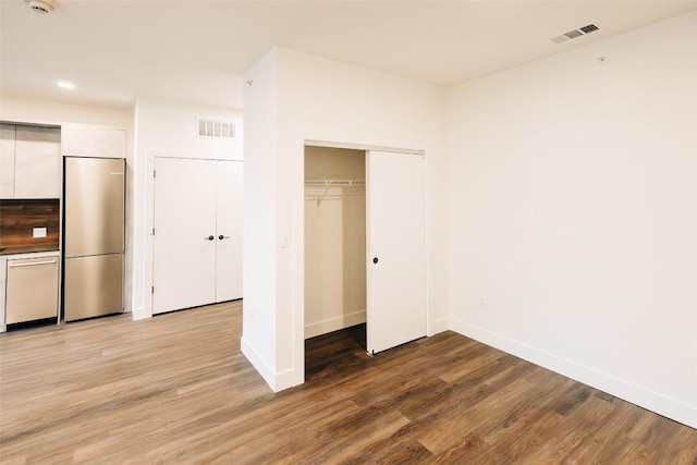 4315 S Congress Ave Unit 520, Austin, TX 78745 - unfurnished bedroom with visible vents, light wood-style floors, a closet, and built in fridge