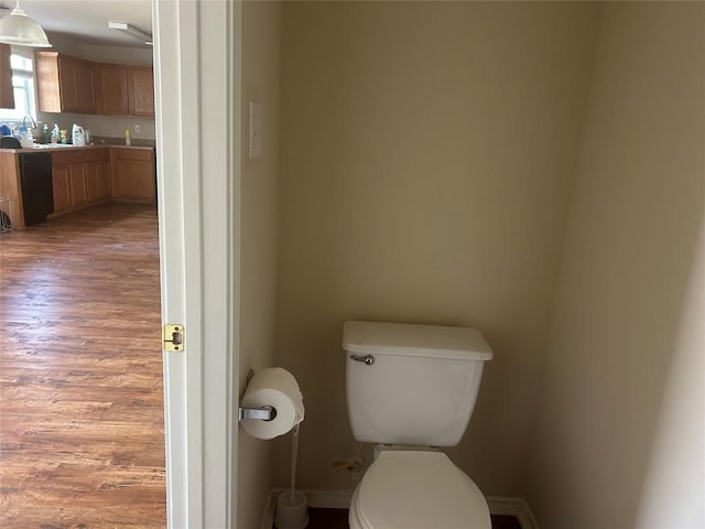 bathroom featuring toilet, vanity, wood finished floors, and baseboards