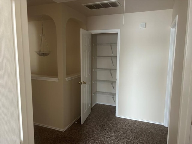 hall featuring carpet flooring, visible vents, and baseboards