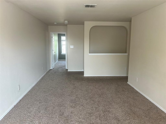 carpeted spare room featuring visible vents and baseboards