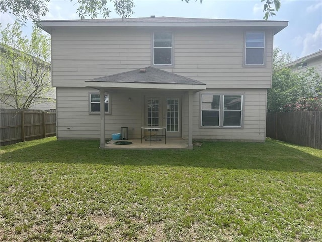 rear view of house with a yard, a patio, and a fenced backyard