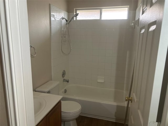 full bath with toilet, wood finished floors, vanity, and  shower combination