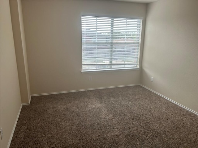 unfurnished room with baseboards and carpet