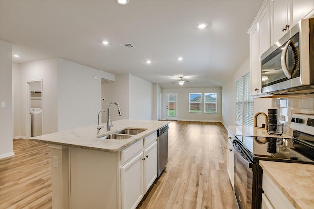 105 Saviano Rd, Hutto, TX 78634 - kitchen featuring stainless steel appliances, a sink, light wood-style floors, a kitchen island with sink, and open floor plan