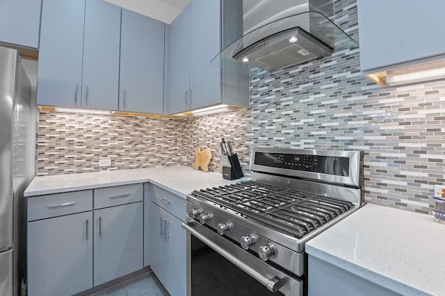 8922 Menchaca Rd Unit 204, Austin, TX 78748 - kitchen featuring appliances with stainless steel finishes, wall chimney exhaust hood, decorative backsplash, blue cabinets, and light stone countertops