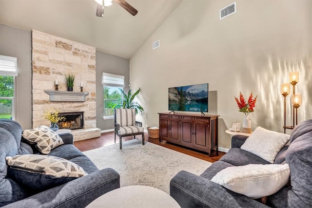 18003 Linkhill Dr, Dripping Springs, TX 78620 - living area with plenty of natural light, wood finished floors, ceiling fan, high vaulted ceiling, and a stone fireplace