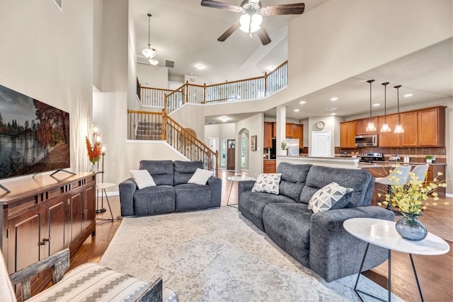 18003 Linkhill Dr, Dripping Springs, TX 78620 - living area featuring stairs, a towering ceiling, ceiling fan, baseboards, and wood finished floors