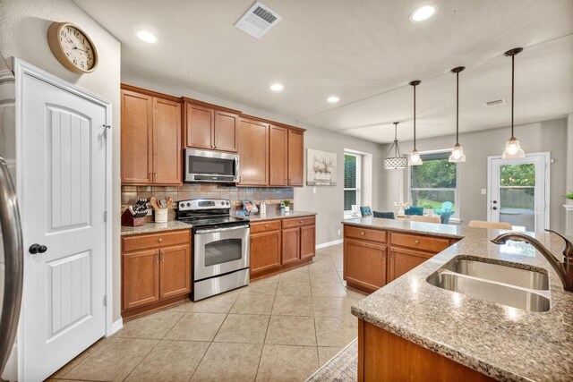 18003 Linkhill Dr, Dripping Springs, TX 78620 - kitchen with stainless steel appliances, a sink, recessed lighting, brown cabinets, and decorative backsplash