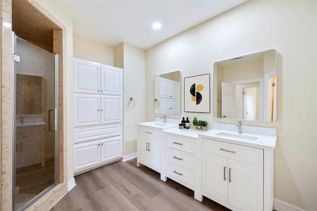 8316 Talbot Ln, Austin, TX 78746 - full bath with double vanity, a shower stall, wood finished floors, and baseboards
