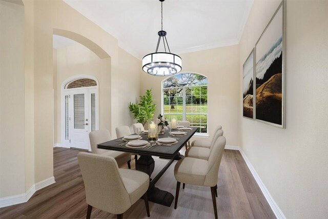 8316 Talbot Ln, Austin, TX 78746 - dining space featuring arched walkways, wood finished floors, a chandelier, and baseboards