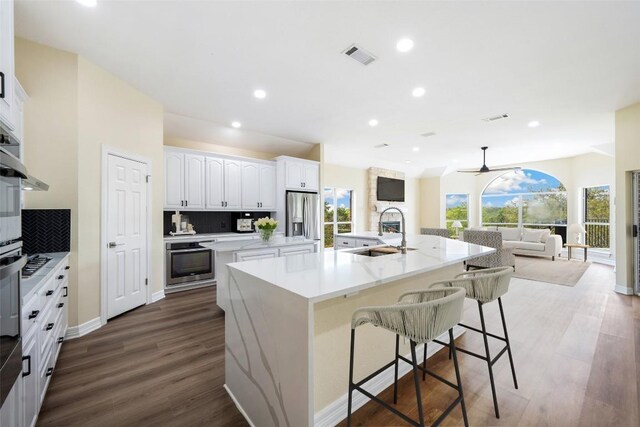 8316 Talbot Ln, Austin, TX 78746 - kitchen with a sink, a large island, appliances with stainless steel finishes, open floor plan, and dark wood-type flooring
