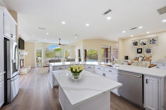 8316 Talbot Ln, Austin, TX 78746 - kitchen with appliances with stainless steel finishes, a large island with sink, a sink, open floor plan, and dark wood-style floors