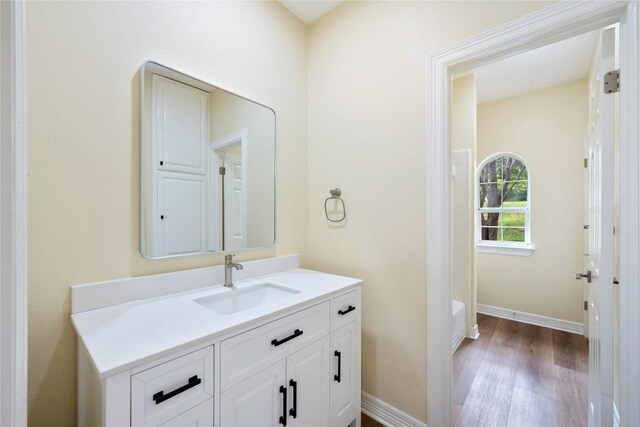 8316 Talbot Ln, Austin, TX 78746 - full bath featuring vanity, wood finished floors, baseboards, and a tub to relax in