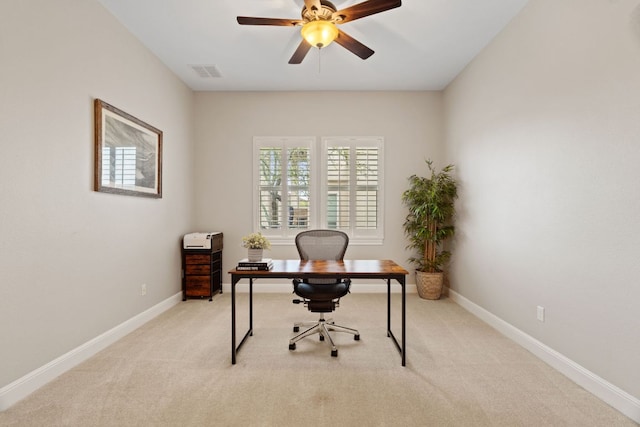 home office with visible vents, a ceiling fan, baseboards, and light carpet