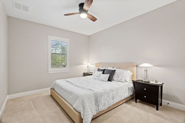 carpeted bedroom with baseboards, a ceiling fan, and visible vents