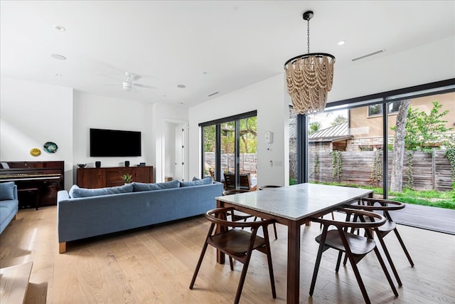 dining room featuring ceiling fan with notable chandelier, light wood finished floors, visible vents, and recessed lighting