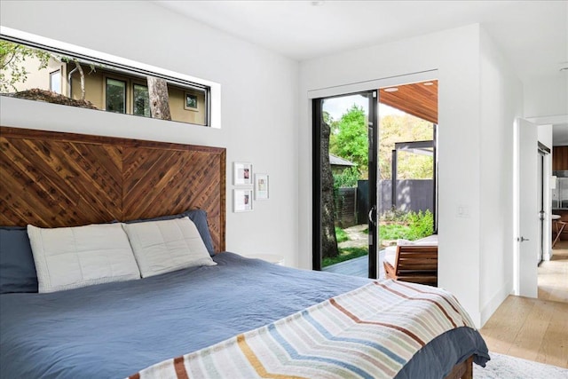 bedroom with access to exterior and wood finished floors