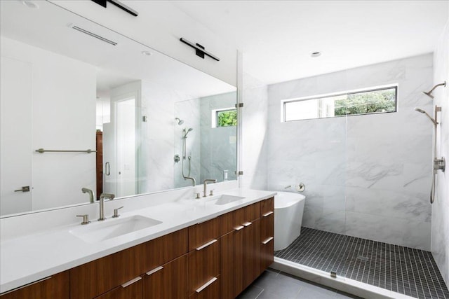 bathroom featuring a sink, tile patterned flooring, a marble finish shower, and double vanity
