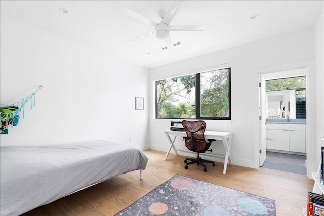 bedroom featuring wood finished floors, ceiling fan, baseboards, and multiple windows