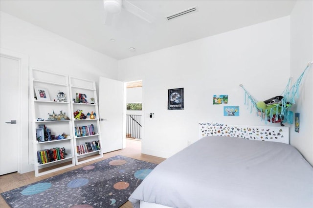 bedroom featuring wood finished floors, a ceiling fan, and visible vents