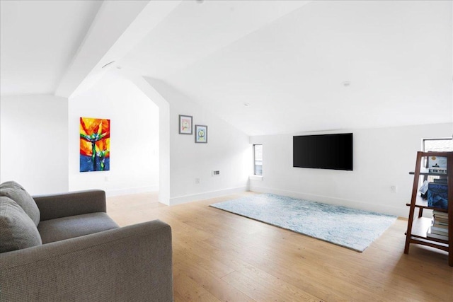 living room with light wood-style floors, baseboards, and lofted ceiling