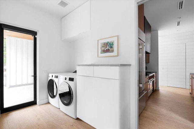 3313 Bonnie Rd, Austin, TX 78703 - laundry area with washer and clothes dryer, light wood finished floors, and cabinet space