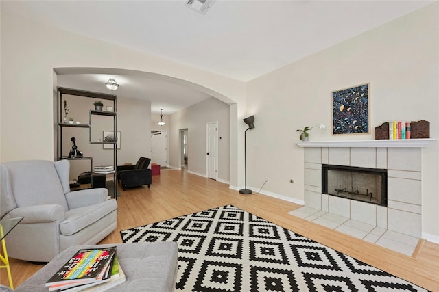 5216 Trading Bnd, Austin, TX 78735 - living room featuring arched walkways, wood finished floors, a fireplace, and baseboards