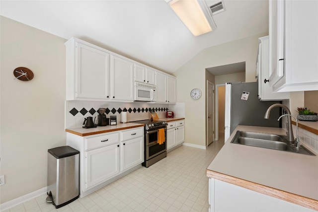 5216 Trading Bnd, Austin, TX 78735 - kitchen featuring white microwave, electric stove, a sink, backsplash, and vaulted ceiling