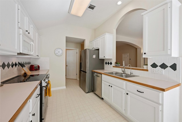 5216 Trading Bnd, Austin, TX 78735 - kitchen with stainless steel appliances, a sink, arched walkways, white cabinetry, and light countertops