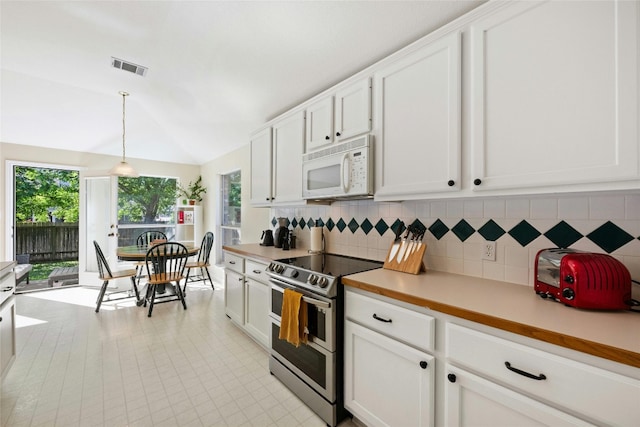 5216 Trading Bnd, Austin, TX 78735 - kitchen with stainless steel electric range oven, white microwave, decorative backsplash, light countertops, and lofted ceiling